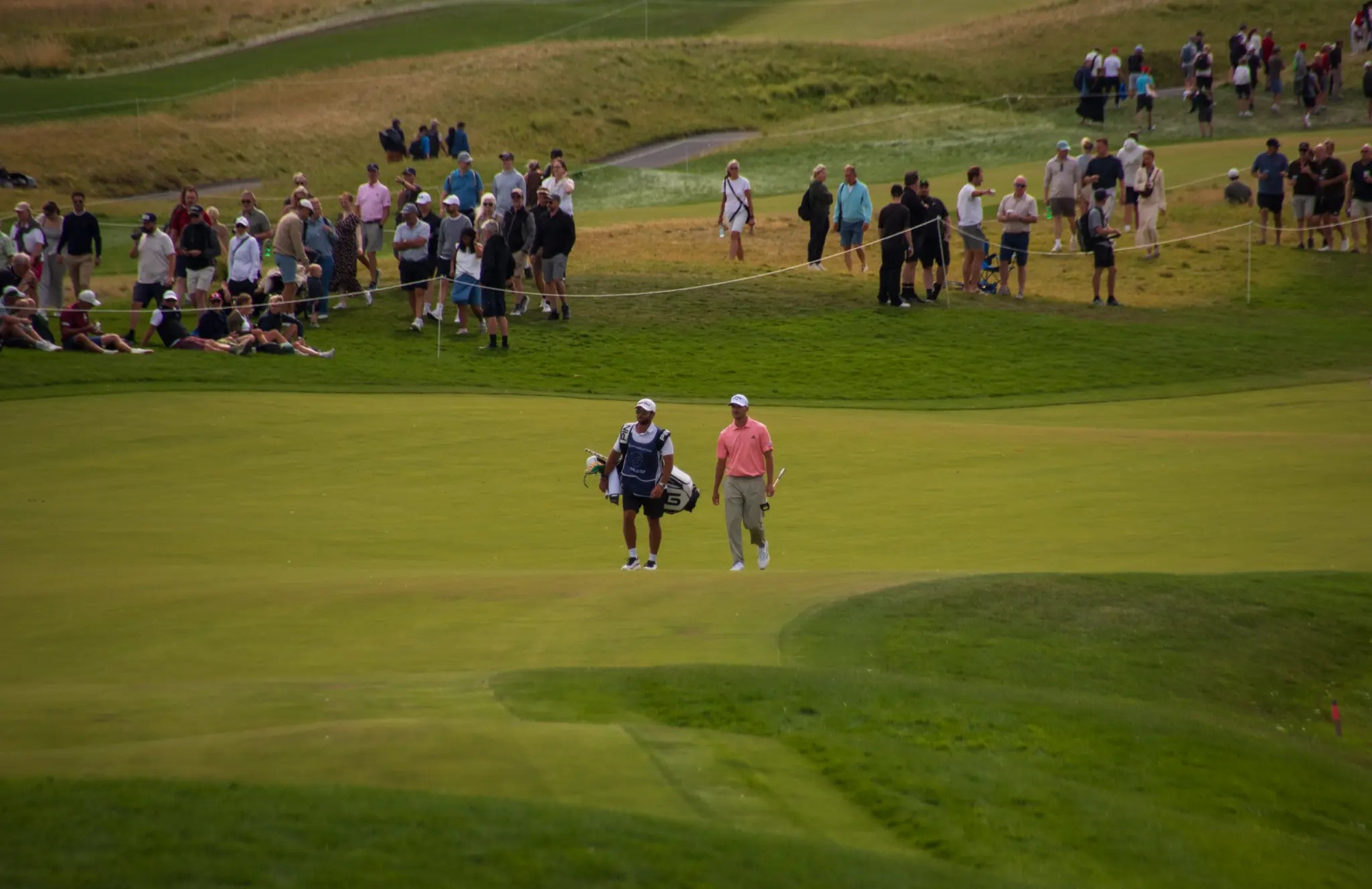 Rasmus Højgaard med caddie foran tilskuere på Great Northern under Danish Golf Championship